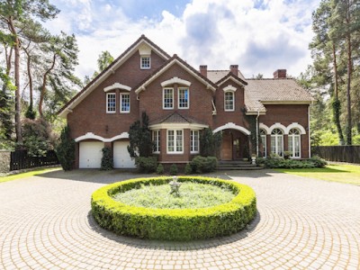 location 3 ppeebmdjlmgo2ns363zmzrokqt9u8k3ydqsej30vqw About Homey Front view of a driveway with a round garden and big, english style house in the background. Real photo
